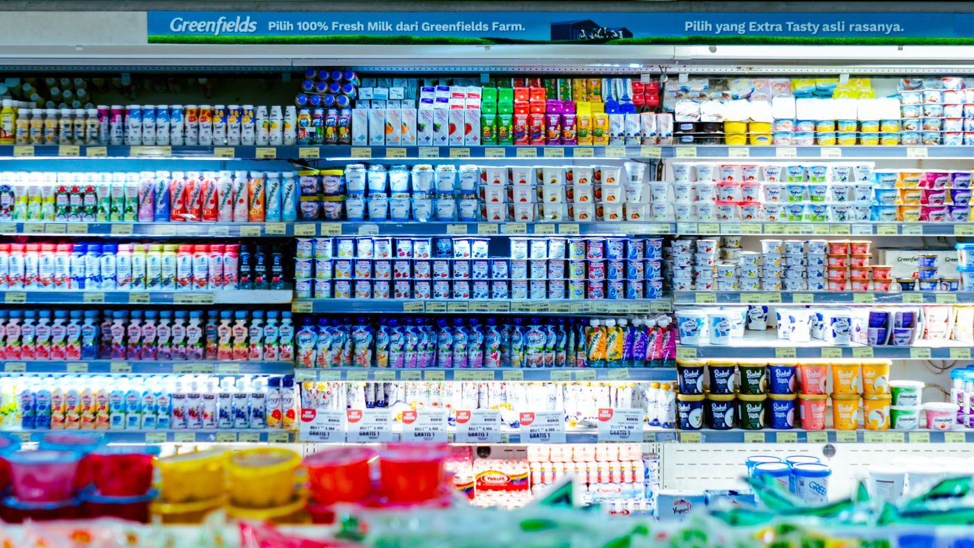 Refrigerated dairy cases in a grocery store aisle