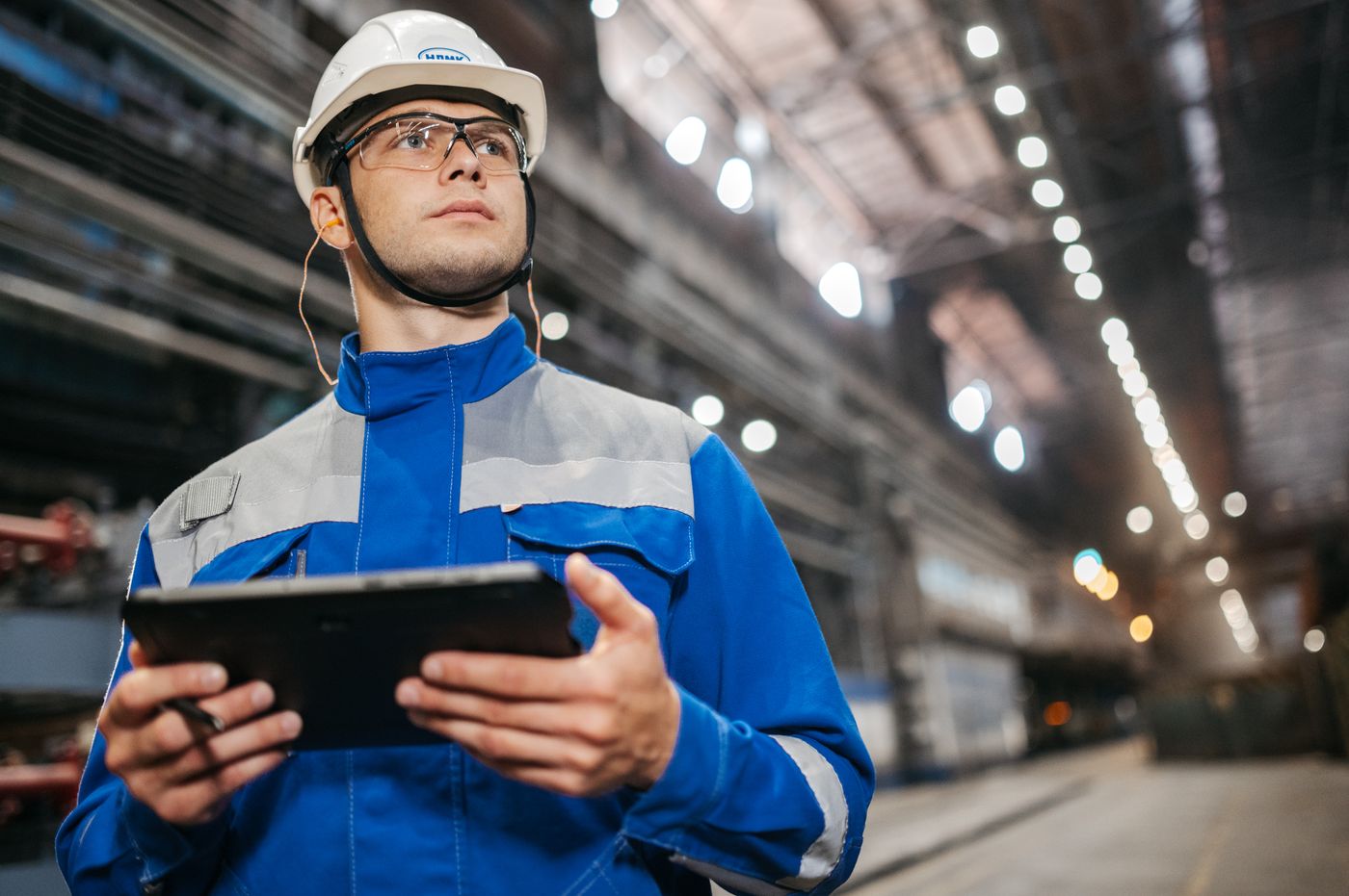 Facility worker checking live data on a tablet on the plant floor